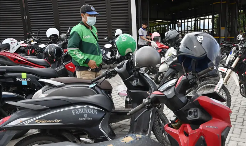 Seorang pengemudi ojek online memarkir sepeda motornya di tempat parkir kendaraan di Palu, Sulawesi Tengah, Sabtu (6/9/2025). (©bmzIMAGES/basri marzuki)